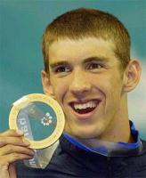 Michael Phelps with short hair holding gold medal.jpg

